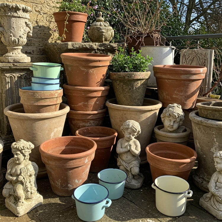Vintage Garten Dekoration, zu sehen Steinfiguren Pflaztöpfe aus Ton, alte Emaille Schalen und Töpfe in einem romantischen Garten. 